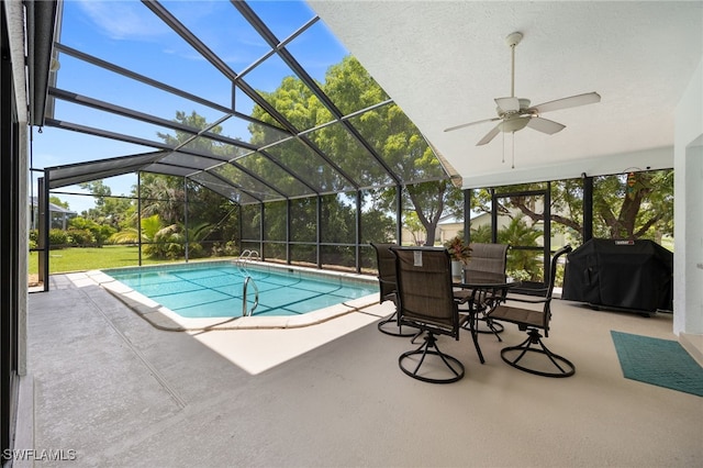 outdoor pool featuring area for grilling, a patio area, a ceiling fan, and glass enclosure