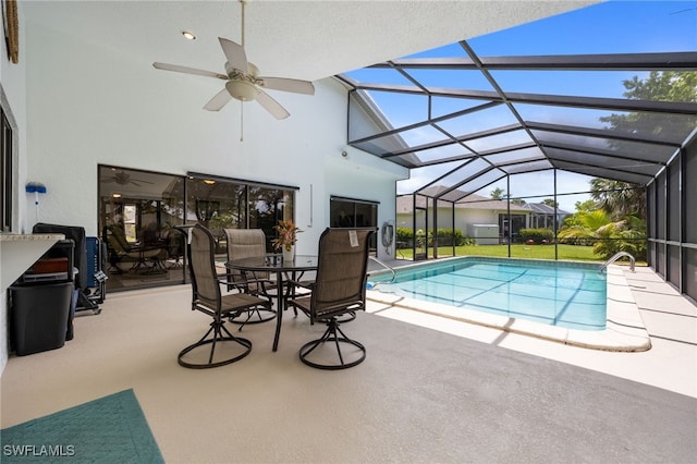 outdoor pool with a patio area, a ceiling fan, and a lanai