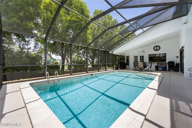 swimming pool with a ceiling fan, a patio area, and glass enclosure