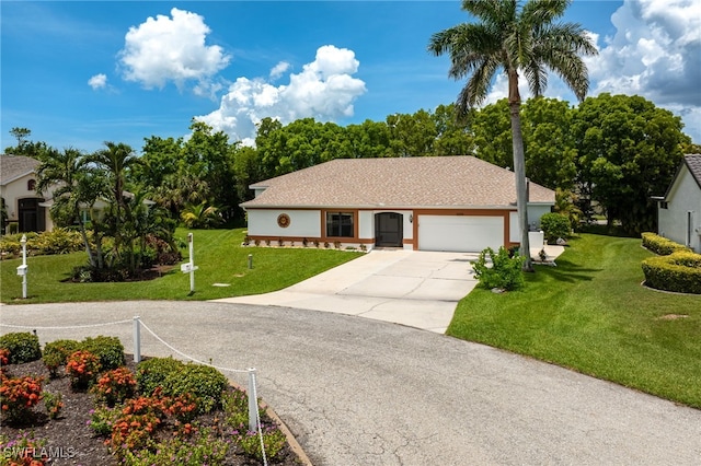 ranch-style house featuring a front yard, driveway, an attached garage, and stucco siding