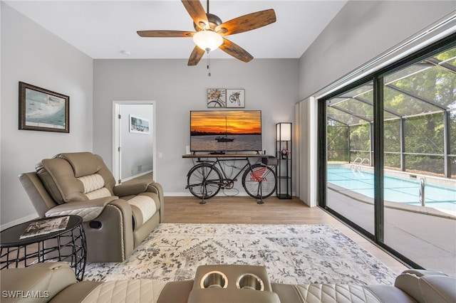 living room with ceiling fan, wood finished floors, and a sunroom