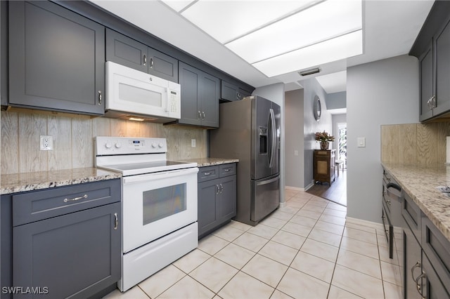 kitchen featuring white appliances, backsplash, light tile patterned floors, and light stone counters