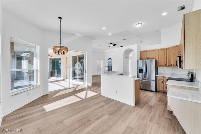 2313 SE 20th Pl, Cape Coral, FL 33990 - kitchen with stainless steel fridge, light countertops, arched walkways, a chandelier, and light wood-type flooring