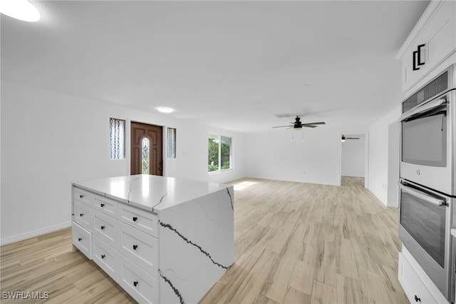 3307 Pinetree St, Port Charlotte, FL 33952 - kitchen featuring stainless steel double oven, white cabinets, ceiling fan, and light stone countertops