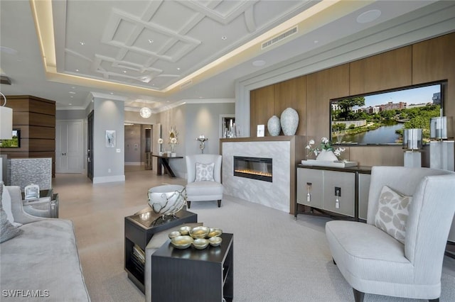 living room with a fireplace, crown molding, light colored carpet, and a tray ceiling