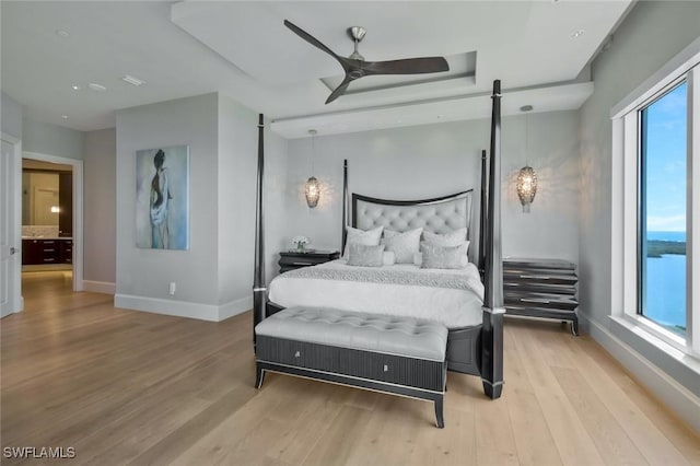 bedroom featuring light wood-style floors, multiple windows, and ceiling fan
