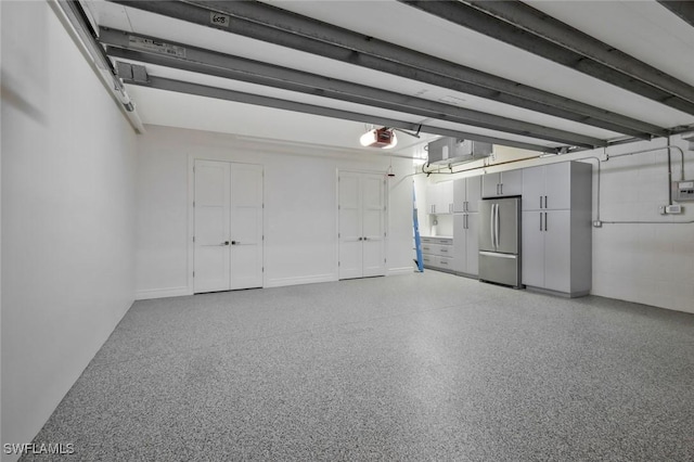 garage featuring freestanding refrigerator and a garage door opener