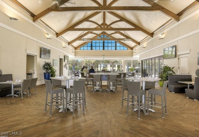dining room with high vaulted ceiling and beamed ceiling