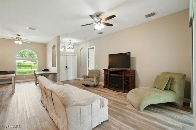 3271 Lemon Ln, Naples, FL 34120 - living room with arched walkways, a ceiling fan, light wood-style flooring, and a fireplace