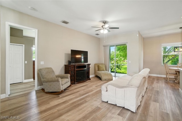3271 Lemon Ln, Naples, FL 34120 - living area featuring ceiling fan, a fireplace, and light wood-style floors