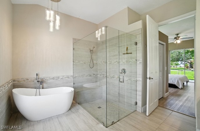 3271 Lemon Ln, Naples, FL 34120 - ensuite bathroom with a stall shower, a freestanding bath, tile walls, ceiling fan, and a wainscoted wall