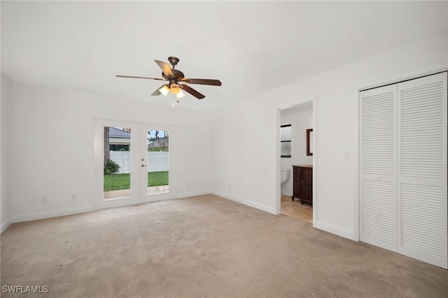 519 99th Ave N, Naples, FL 34108 - unfurnished bedroom with light carpet, access to exterior, french doors, ensuite bath, and ceiling fan