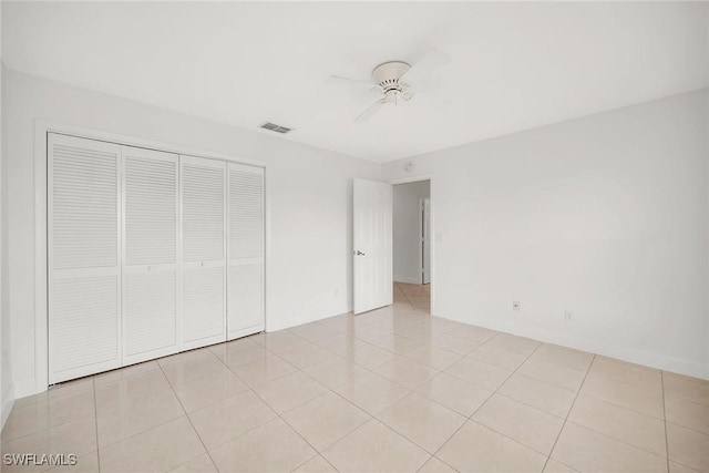 519 99th Ave N, Naples, FL 34108 - unfurnished bedroom with a closet, ceiling fan, and light tile patterned flooring