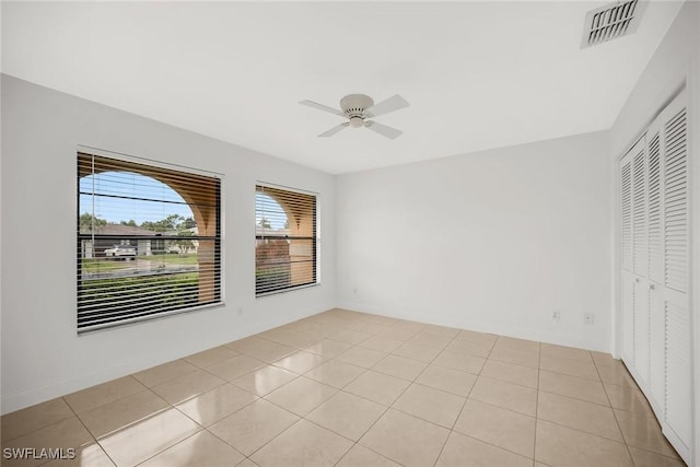 519 99th Ave N, Naples, FL 34108 - unfurnished bedroom featuring a closet, a ceiling fan, and light tile patterned flooring
