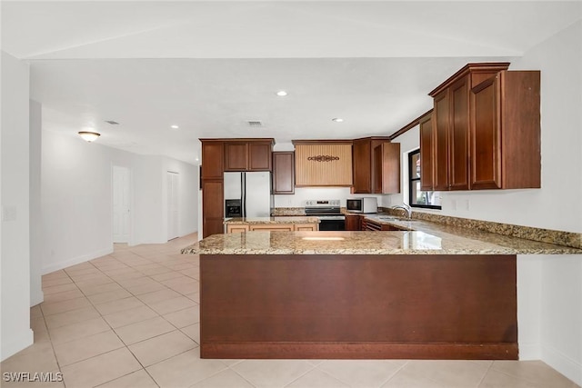 519 99th Ave N, Naples, FL 34108 - kitchen featuring stainless steel appliances, a peninsula, light stone counters, light tile patterned flooring, and recessed lighting