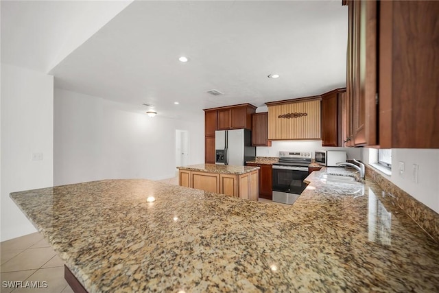 519 99th Ave N, Naples, FL 34108 - kitchen with stainless steel appliances, a kitchen island, light stone counters, a peninsula, and recessed lighting