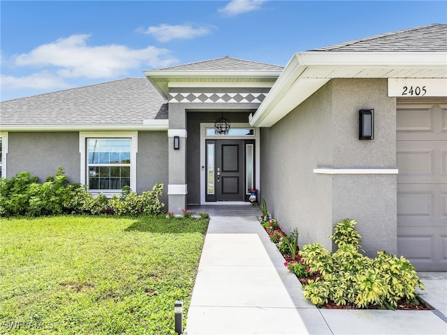 2405 Nelson Rd N, Cape Coral, FL 33993 - view of exterior entry with a lawn, stucco siding, and roof with shingles