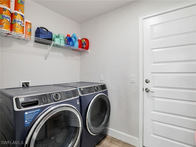 2405 Nelson Rd N, Cape Coral, FL 33993 - laundry room featuring washer and clothes dryer and light wood-style flooring