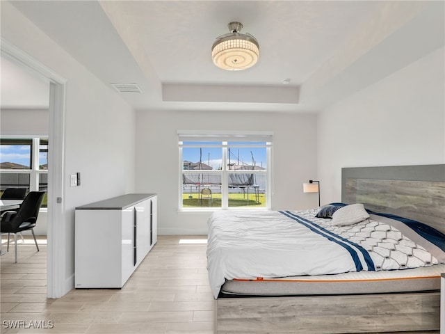 2405 Nelson Rd N, Cape Coral, FL 33993 - bedroom featuring a tray ceiling and light wood-style flooring