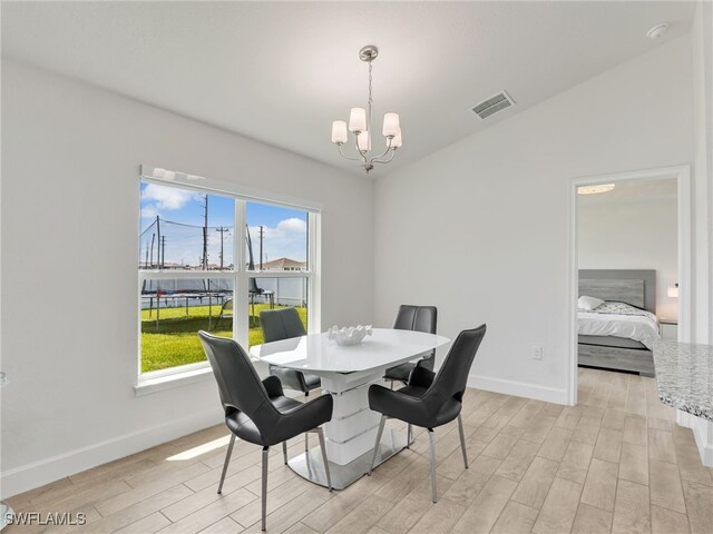 2405 Nelson Rd N, Cape Coral, FL 33993 - dining area with a chandelier and light wood-style floors