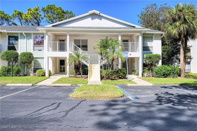 1140 Sarah Jean Cir Unit C-205, Naples, FL 34110 - view of building exterior with stairway and uncovered parking