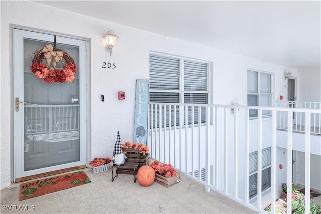 1140 Sarah Jean Cir Unit C-205, Naples, FL 34110 - doorway to property with stucco siding and a porch