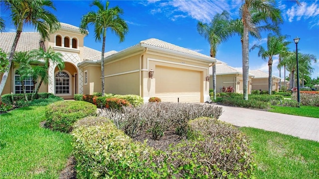 20029 Saraceno Dr, Estero, FL 33928 - mediterranean / spanish-style house with a garage, driveway, a tile roof, and stucco siding