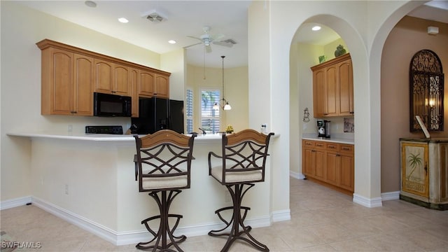 20029 Saraceno Dr, Estero, FL 33928 - kitchen with black appliances, a ceiling fan, a kitchen breakfast bar, a peninsula, and arched walkways