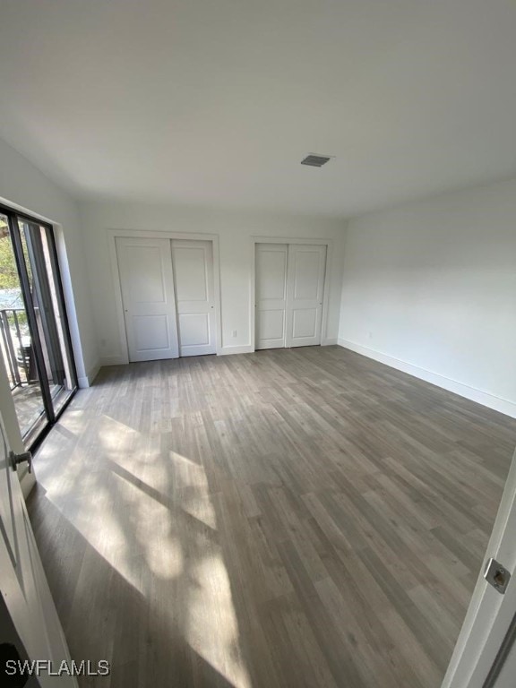 17989 San Juan Ct Unit 3, Fort Myers, FL 33967 - unfurnished bedroom featuring multiple closets and wood finished floors