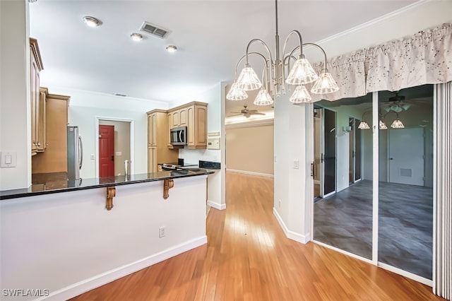 15050 Lakeside View Dr Unit 1003, Fort Myers, FL 33919 - kitchen featuring ceiling fan, stainless steel appliances, light wood-style floors, dark countertops, and ornamental molding