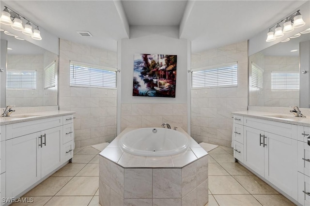 2502 SW 17th Ave, Cape Coral, FL 33914 - bathroom featuring tile walls, two vanities, tile patterned flooring, a bath, and a walk in shower