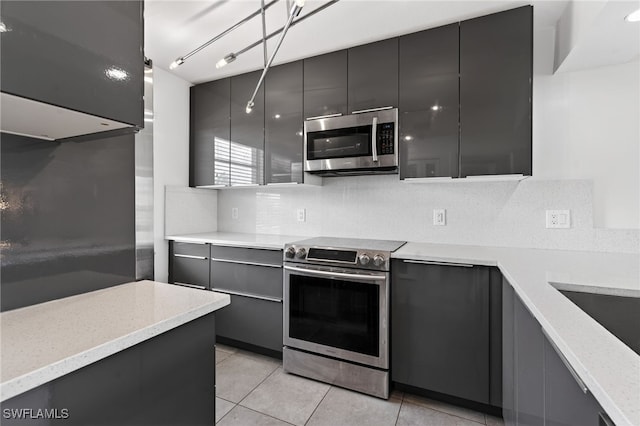 1666 Osprey Ave Unit 106, Naples, FL 34102 - kitchen with appliances with stainless steel finishes, decorative backsplash, light tile patterned flooring, modern cabinets, and dark cabinets