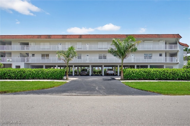 1666 Osprey Ave Unit 106, Naples, FL 34102 - view of apartment building / complex featuring covered parking