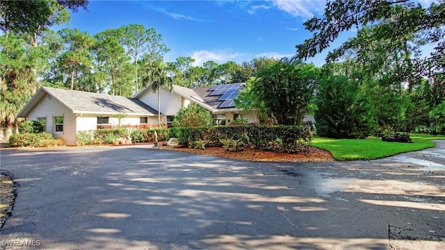 5961 Sea Grass Ln, Naples, FL 34116 - view of front of house with asphalt driveway and roof mounted solar panels