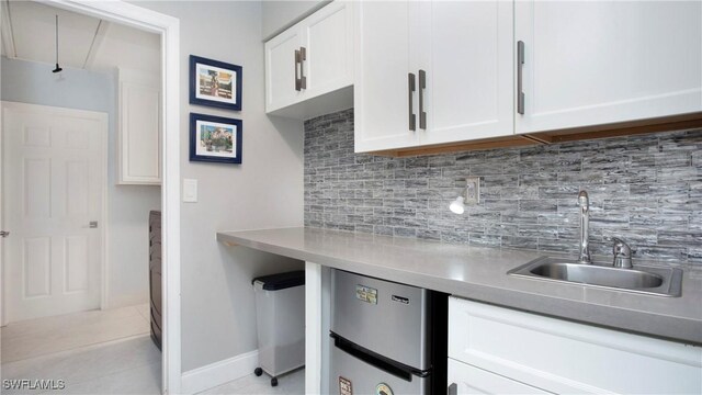 5961 Sea Grass Ln, Naples, FL 34116 - kitchen featuring refrigerator, white cabinetry, light tile patterned floors, and decorative backsplash