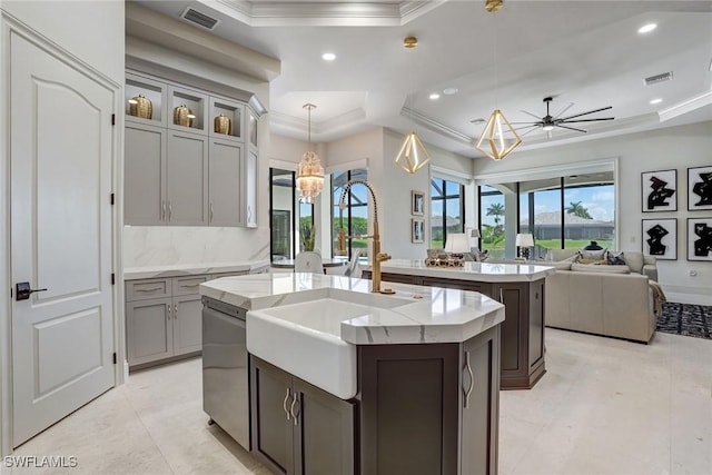 9691 Monteverdi Way, Fort Myers, FL 33912 - kitchen with a tray ceiling, a center island with sink, ornamental molding, open floor plan, and decorative light fixtures