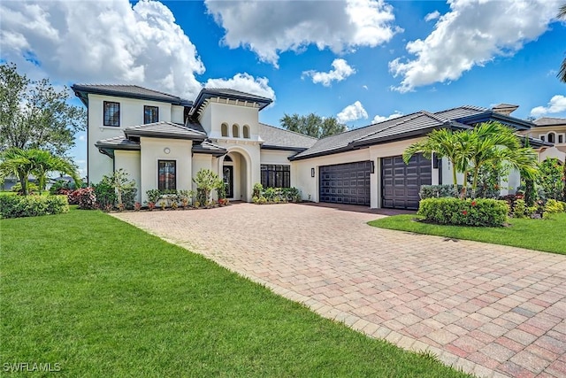 9691 Monteverdi Way, Fort Myers, FL 33912 - mediterranean / spanish-style home featuring decorative driveway, a garage, a front lawn, and stucco siding