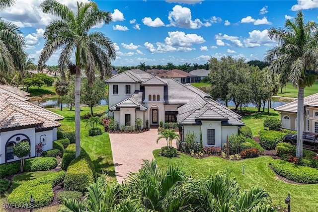 9691 Monteverdi Way, Fort Myers, FL 33912 - view of front of house featuring stucco siding, a front yard, a water view, and decorative driveway