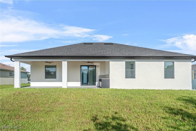 807 Hamilton Ave, Lehigh Acres, FL 33972 - back of property featuring a ceiling fan, a yard, a shingled roof, and stucco siding