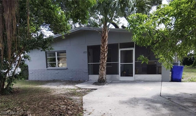 873 Van Buren St, Fort Myers, FL 33916 - view of front facade with a sunroom, stone siding, and stucco siding