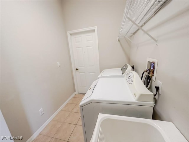 2041 24th Ave NE, Naples, FL 34120 - washroom featuring washer and clothes dryer and light tile patterned floors