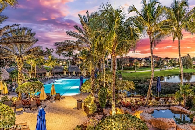 8331 Adelio Ln, Fort Myers, FL 33912 - pool at dusk with a community pool and a patio