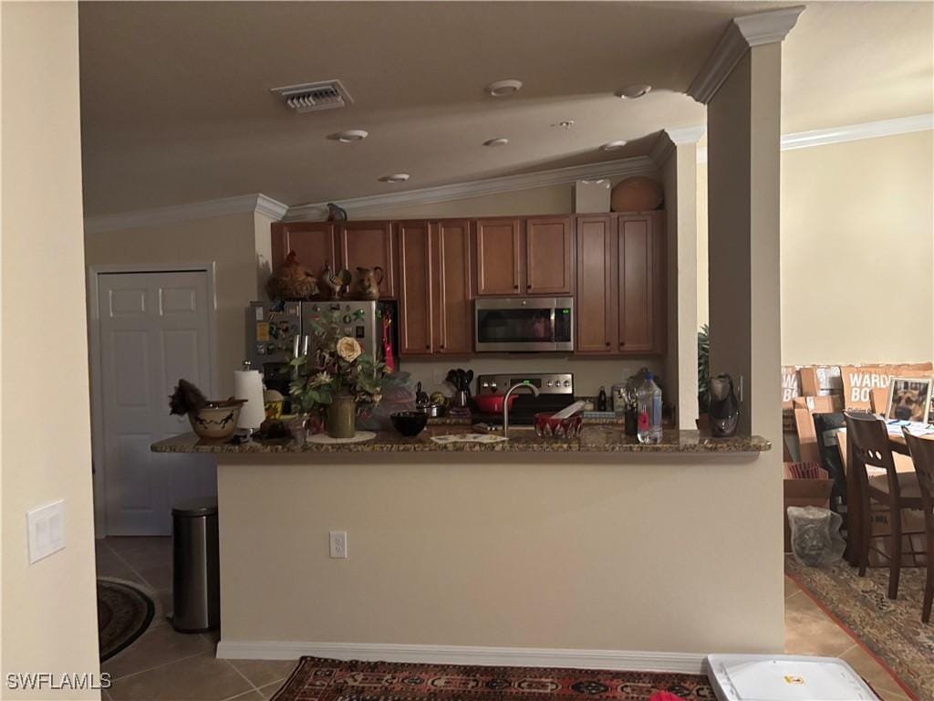 13761 Julias Way Unit 323, Fort Myers, FL 33919 - kitchen with stainless steel appliances, dark stone counters, light tile patterned floors, a peninsula, and ornamental molding