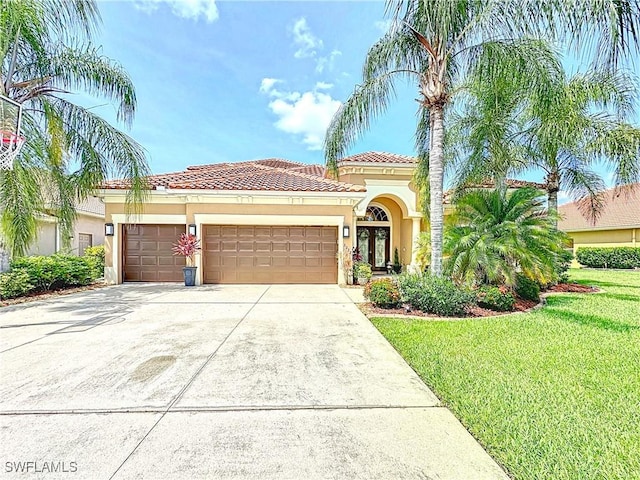 3032 Via Rialto St, Fort Myers, FL 33905 - mediterranean / spanish-style home with stucco siding, an attached garage, a front lawn, concrete driveway, and a tiled roof