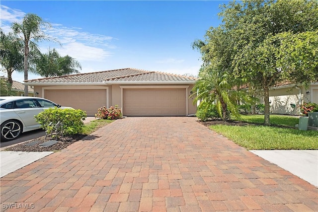 2042 Tamarron Ln, Naples, FL 34120 - view of front of house with decorative driveway, a tiled roof, an attached garage, and stucco siding