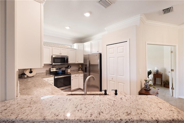 2042 Tamarron Ln, Naples, FL 34120 - kitchen with appliances with stainless steel finishes, white cabinets, light stone countertops, decorative backsplash, and ornamental molding