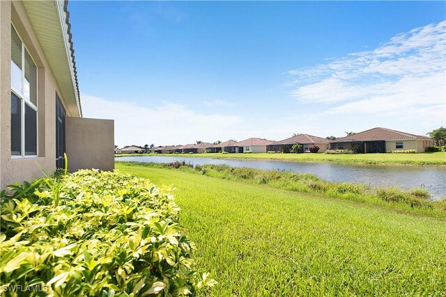 2042 Tamarron Ln, Naples, FL 34120 - view of green lawn with a water view and a residential view