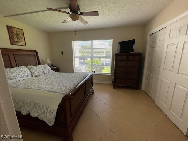 1414 SE 46th St Unit 1C, Cape Coral, FL 33904 - bedroom with light tile patterned flooring, a textured ceiling, a closet, and a ceiling fan
