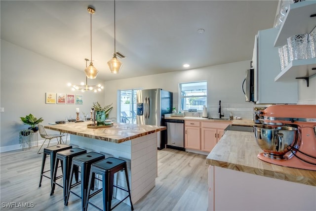 917 SW 23rd St, Cape Coral, FL 33991 - kitchen featuring stainless steel appliances, light wood-style floors, a kitchen breakfast bar, decorative light fixtures, and recessed lighting