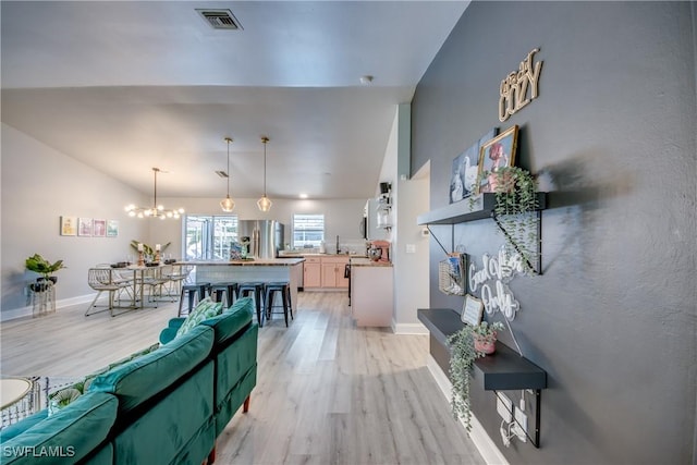 917 SW 23rd St, Cape Coral, FL 33991 - living area with light wood-style floors, a chandelier, and vaulted ceiling